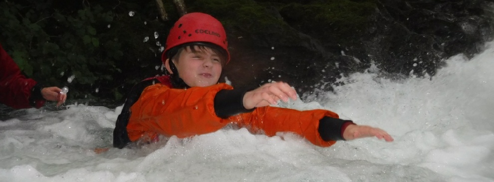 Scrambling across a gorge in high water.